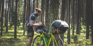 Historie z sakwami: pracę w korpo zamienił na życie w siodełku Rowerzysta bikepackingowy sprawdza sakwy w zielonym polskim lesie