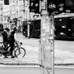 Dwóch rowerzystów czeka na światłach na ruchliwym miejskim skrzyżowaniu