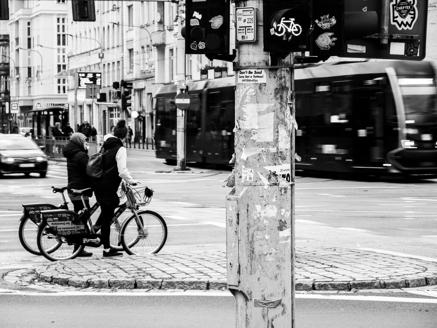 Dwóch rowerzystów czeka na światłach na ruchliwym miejskim skrzyżowaniu