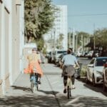 Dwóch rowerzystów jedzie swobodnie ulicą w słoneczny dzień