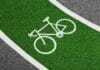 Nowe inicjatywy samorządów: miejskie programy i budżety na infrastrukturę rowerową Jasnozielona ścieżka rowerowa z białym symbolem roweru