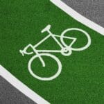 Jasnozielona ścieżka rowerowa z białym symbolem roweru