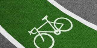 Jasnozielona ścieżka rowerowa z białym symbolem roweru
