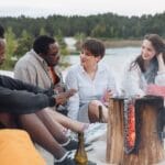 Przyjaciele rowerzyści siedzą przy ognisku na piaszczystej plaży